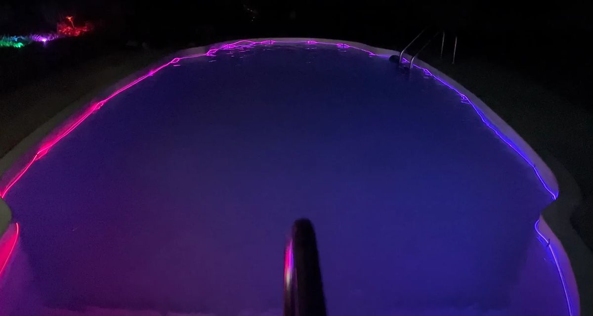 A swimming pool rimmed with diffusive Trippy Wire, magenta on one side and blue on the other.
