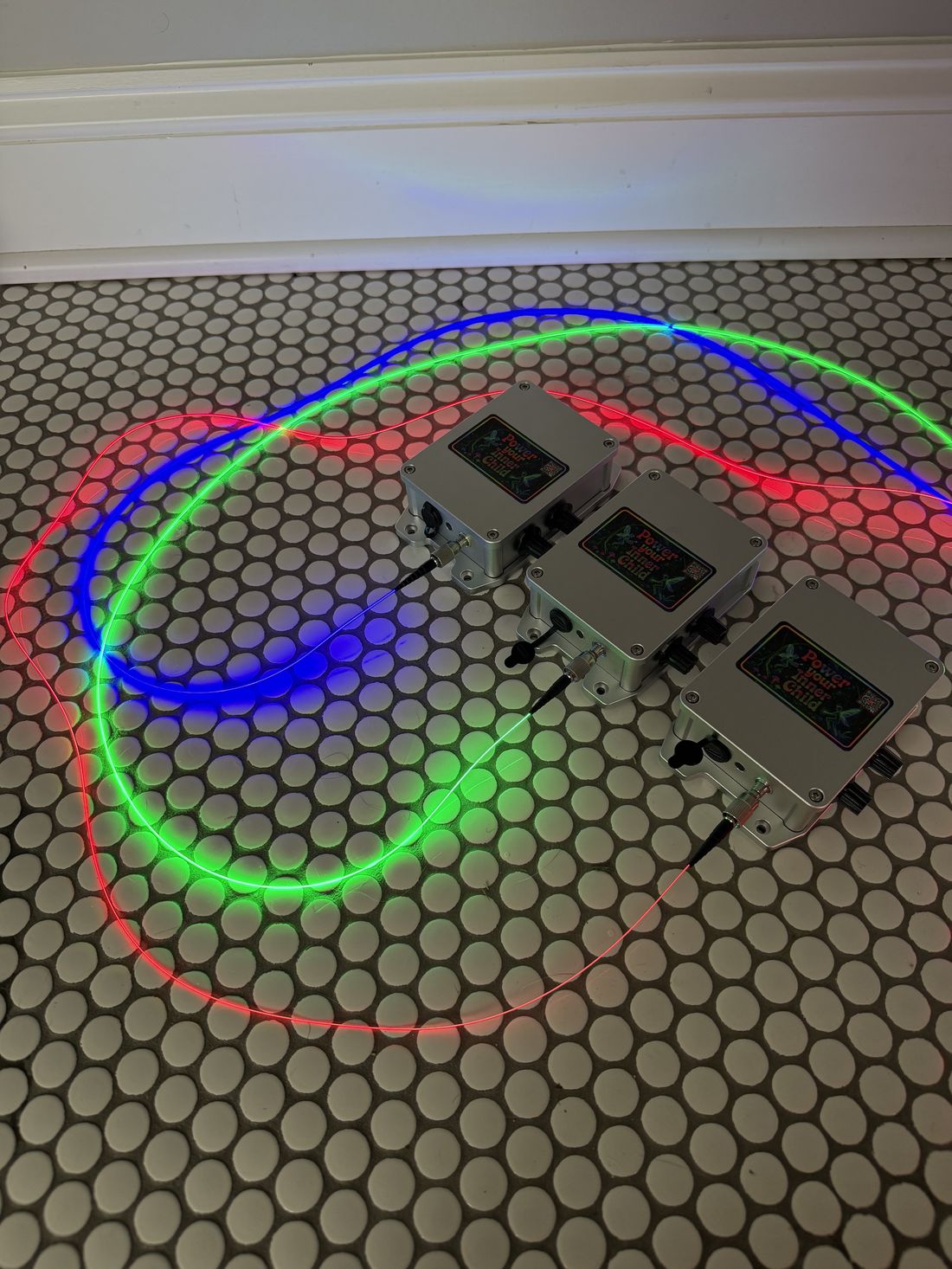 Three illuminator units running red, green, and blue premium Trippy Wire on a tile floor.
